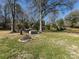 A spacious backyard with a grill, fire pit, and picnic table, perfect for outdoor entertaining and relaxation at 7037 Wrentree Dr, Charlotte, NC 28210