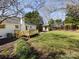Enjoy this backyard with a deck, outbuilding, mature trees, and lush lawn at 7037 Wrentree Dr, Charlotte, NC 28210