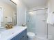 Bathroom with a glass enclosed shower, blue vanity, gold fixtures and a gold framed mirror at 7037 Wrentree Dr, Charlotte, NC 28210