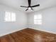 An empty bedroom with hardwood floors and white walls gets ample light from two windows at 7037 Wrentree Dr, Charlotte, NC 28210