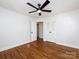 This empty bedroom features a ceiling fan and gleaming hardwood floors at 7037 Wrentree Dr, Charlotte, NC 28210