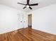 Bright bedroom features wood floors, a ceiling fan, and an open door to the hallway at 7037 Wrentree Dr, Charlotte, NC 28210