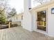 The back of this beautiful white brick home has a wooden deck and glass pane door at 7037 Wrentree Dr, Charlotte, NC 28210