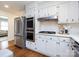 Modern kitchen features stainless steel appliances, white cabinets, and a gas cooktop with a stylish hood at 7037 Wrentree Dr, Charlotte, NC 28210