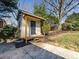 An outbuilding or storage shed has a covered porch and is surrounded by greenery at 7037 Wrentree Dr, Charlotte, NC 28210