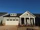 Gray Craftsman style home with a white garage door and landscaping at 7050 Wayfarer Dr # 0085, Charlotte, NC 28269