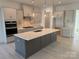 Modern kitchen with gray cabinets, white quartz island, and stainless steel appliances at 7050 Wayfarer Dr # 0085, Charlotte, NC 28269