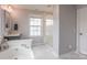 Bright bathroom with a tub, glass-enclosed shower, and a modern vanity with granite counters at 17611 Austins Creek Dr, Charlotte, NC 28278