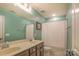 Well-lit bathroom with double sinks, a vanity, and a shower with a patterned shower curtain at 17611 Austins Creek Dr, Charlotte, NC 28278