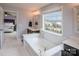 Bright bathroom featuring a large tub, double vanities, and a window with a neighborhood view at 17611 Austins Creek Dr, Charlotte, NC 28278