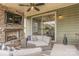 Inviting covered patio with stone fireplace, ceiling fan, and comfortable seating at 17611 Austins Creek Dr, Charlotte, NC 28278