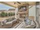 Inviting covered patio with stone fireplace, ceiling fan, and comfortable seating at 17611 Austins Creek Dr, Charlotte, NC 28278