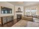 Cozy living room features a fireplace, large windows, hardwood floors, and a large sectional sofa at 17611 Austins Creek Dr, Charlotte, NC 28278