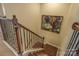 Upper staircase featuring hardwood steps, iron railings, and neutral wall colors at 17611 Austins Creek Dr, Charlotte, NC 28278
