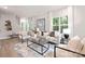 Bright living room with beige sofa, large windows, and wood floors at 1817 Vista Ter, Statesville, NC 28677