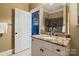 Bathroom featuring a granite countertop vanity and a view into a room with sports decor at 3042 Kings Manor Dr, Weddington, NC 28104