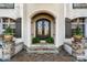 Elegant front entrance with ornate iron doors, stone steps, and decorative planters at 3042 Kings Manor Dr, Weddington, NC 28104