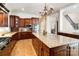 Elegant kitchen showcasing wood cabinetry, granite countertops, a large island, and stainless steel appliances at 3042 Kings Manor Dr, Weddington, NC 28104