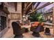 A covered outdoor kitchen and dining area, with fireplace, wicker chairs, and stainless steel appliances at 3042 Kings Manor Dr, Weddington, NC 28104