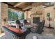 Outdoor patio with a stone fireplace and comfortable seating with views of the landscaped backyard at 3042 Kings Manor Dr, Weddington, NC 28104