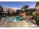 A beautiful outdoor pool area with a cabana, patio, basketball court, and fire bowls at dusk at 3042 Kings Manor Dr, Weddington, NC 28104