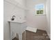 Laundry room with utility sink, shelving and window at 5240 Carden Dr, Charlotte, NC 28227