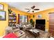 Bright yellow living room with two sofas, a TV, and a ceiling fan at 5927 Pisgah Way, Charlotte, NC 28217