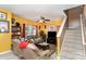 Bright yellow living room with two sofas, a TV, and a ceiling fan at 5927 Pisgah Way, Charlotte, NC 28217