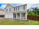 Charming home with inviting porch, and a two-car garage, complemented by a manicured lawn and privacy fence at 11677 Striker Ln, Midland, NC 28107
