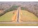 Gorgeous aerial view of new road cutting through a lush, grassy landscape with surrounding trees at 1502 Baileys Run, Gastonia, NC 28056