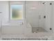 Modern bathroom featuring a tiled tub, window, and glass-enclosed shower at 1502 Baileys Run, Gastonia, NC 28056