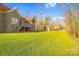 Expansive backyard featuring lush green grass, screened porch, wooded area, and additional storage shed at 3613 Savannah Way, Monroe, NC 28110