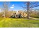 Beautiful two-story home with brick and stone accents surrounded by a lush green lawn and mature trees at 3613 Savannah Way, Monroe, NC 28110