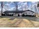 Brick ranch house with dark trim, landscaping, and a large yard at 605 Impala Dr, Albemarle, NC 28001