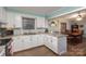 White kitchen with an L-shaped design, granite counters and breakfast bar at 605 Impala Dr, Albemarle, NC 28001