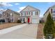 Two-story beige house with red door, landscaping, and driveway at 905 Littleton Dr, Concord, NC 28025