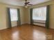 Bright bedroom featuring hardwood floors, neutral walls, ceiling fan, and natural light from the windows at 936 N 5Th St, Albemarle, NC 28001