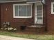 Close up of home's exterior showcasing red brick, window, flowers and a set of stairs at 936 N 5Th St, Albemarle, NC 28001