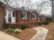 Charming brick home featuring manicured landscaping, a cozy front porch, and decorative flowerbeds at 936 N 5Th St, Albemarle, NC 28001