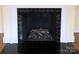 Close up of black tiled fireplace with a decorative mantle and black tile hearth at 936 N 5Th St, Albemarle, NC 28001