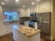 Bright kitchen features granite counters, white cabinets, stainless steel appliances, and center island at 936 N 5Th St, Albemarle, NC 28001