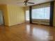 Living room featuring hardwood floors, neutral walls, a ceiling fan and natural light from a large window at 936 N 5Th St, Albemarle, NC 28001