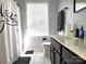 Bathroom featuring a white vanity, dark cabinets and a window letting in lots of natural light at 1009 Murandy Ln, Matthews, NC 28104
