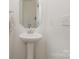 Simple powder room with pedestal sink and octagon mirror at 195 Hidden Lakes Rd, Statesville, NC 28677