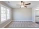 Bright bedroom with carpeted floor, ceiling fan, and large window at 277 Stewart Nw St, Concord, NC 28027