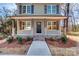 Inviting front porch with wood posts and brick steps leading to the entrance at 277 Stewart Nw St, Concord, NC 28027