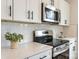 Stainless steel range and microwave, white cabinets, and white subway tile at 3024 Sadler Woods Ln, Charlotte, NC 28214