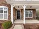 Home's entrance with a black door and stone facade at 1265 Reflection Nw Ave, Concord, NC 28027