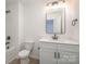 Modern bathroom featuring a white vanity, black matte fixtures, and a large mirror at 3008 Sadler Woods Ln, Charlotte, NC 28214