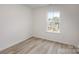 Simple bedroom with large window and wood flooring at 3008 Sadler Woods Ln, Charlotte, NC 28214